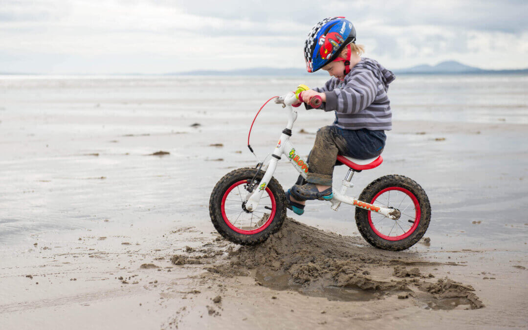 child on bike on beach, North Wales family activities