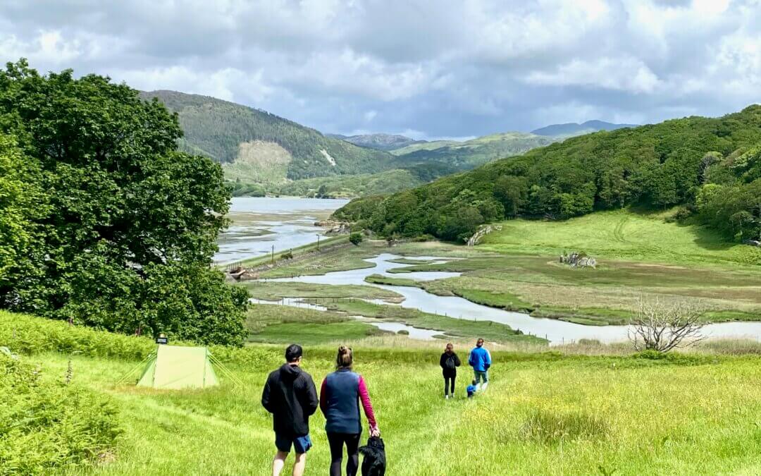 family walking to estuary past tent, Wales family holiday